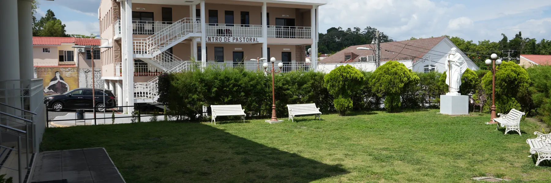 Jard&iacute;n de la parroquia con el Centro de Pastoral al fondo