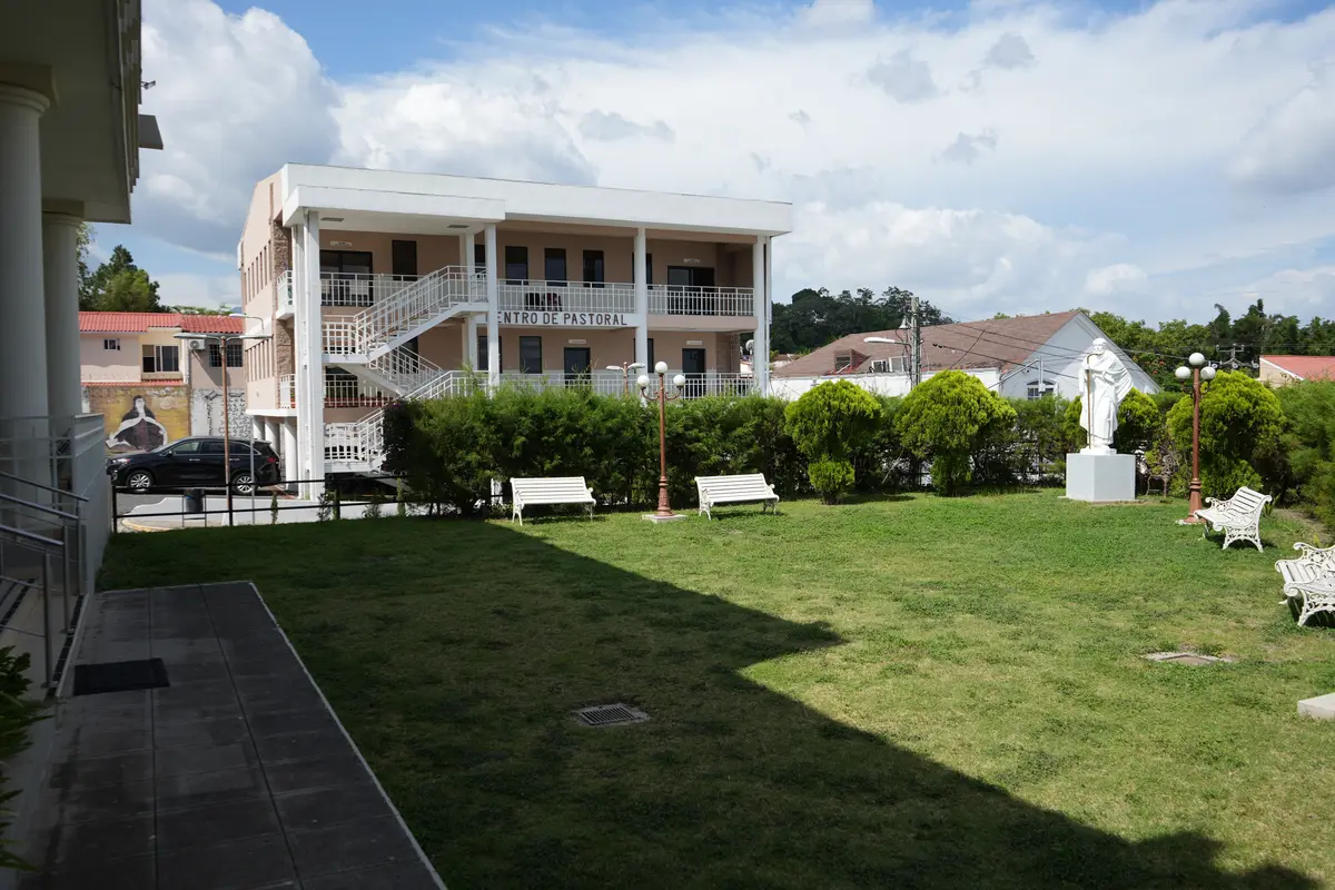 Jardín de la parroquia con las oficinas parroquiales y la casa de retiro al fondo