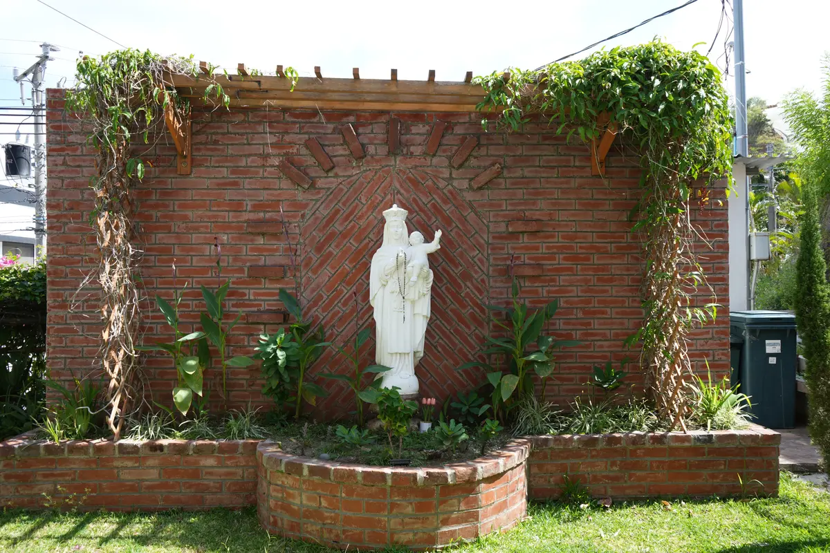 Imagen de la Virgen del Carmen en el jardín exterior de la parroquia